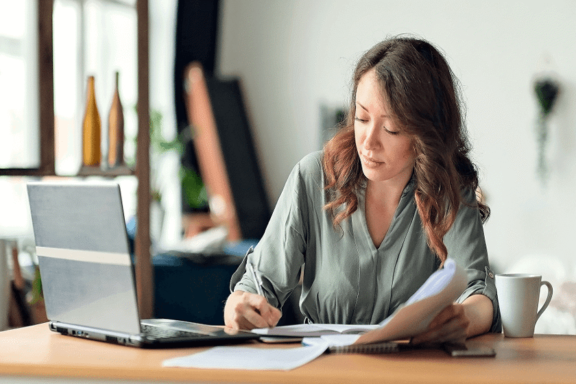 Woman Sitting At Desk Writing 