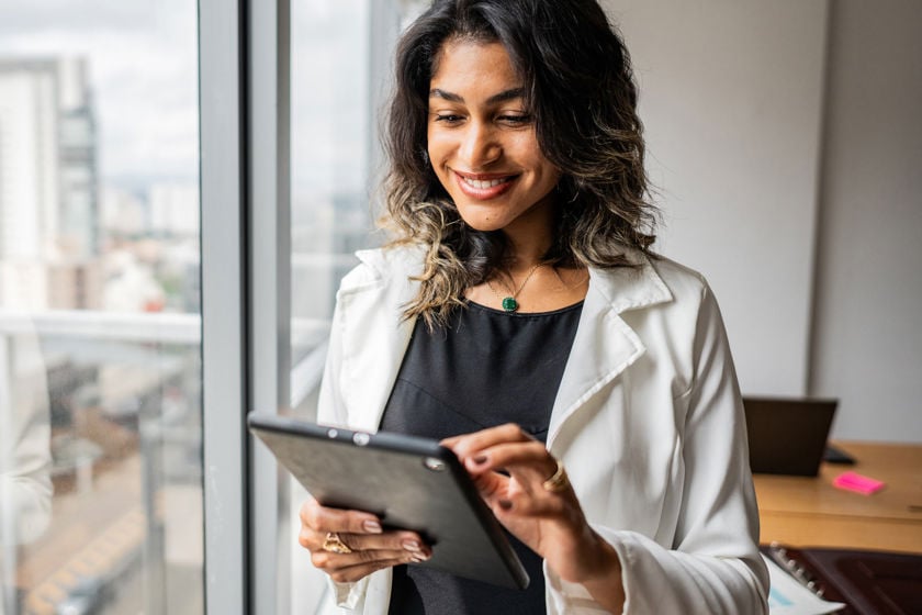 Woman Reviewing Data On Tablet Computer 