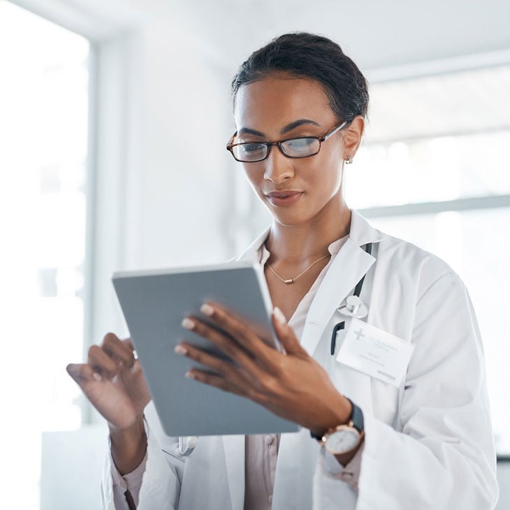 Doctor Reviewing Info On Tablet