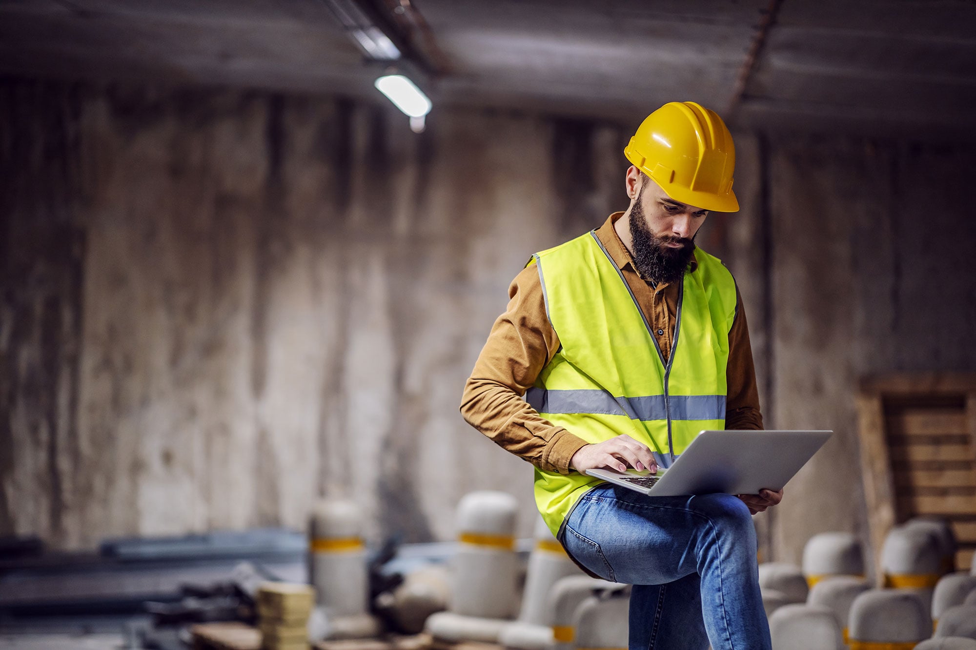 Construction Worker In Viewing Laptop At Jobsite 