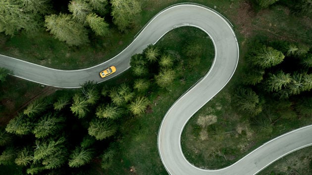 Aerial View Of Car Driving On Winding Road 
