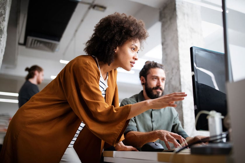 Colleagues Working On Desktop Computer In An Office