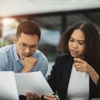 Two Colleagues Reviewing Documents And Laptop 