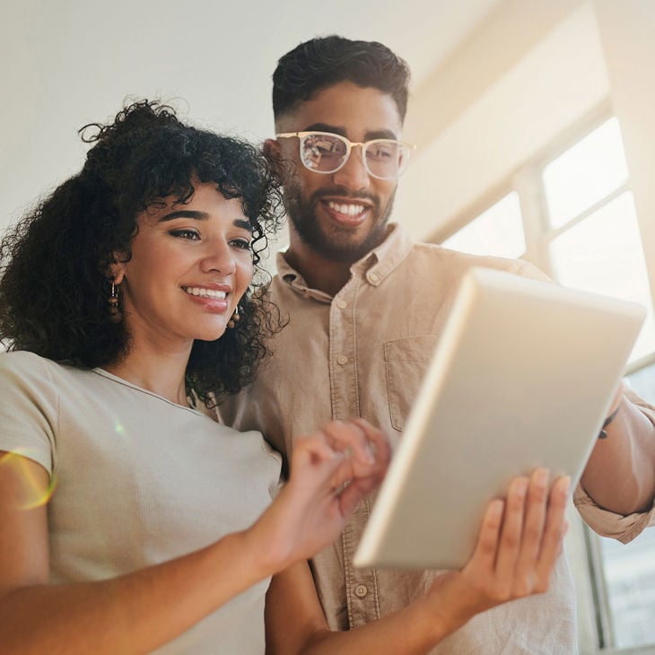 Happy Couple Reviewing Tablet Screen 
