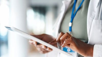 Close Up Of Doctor Using Tablet 