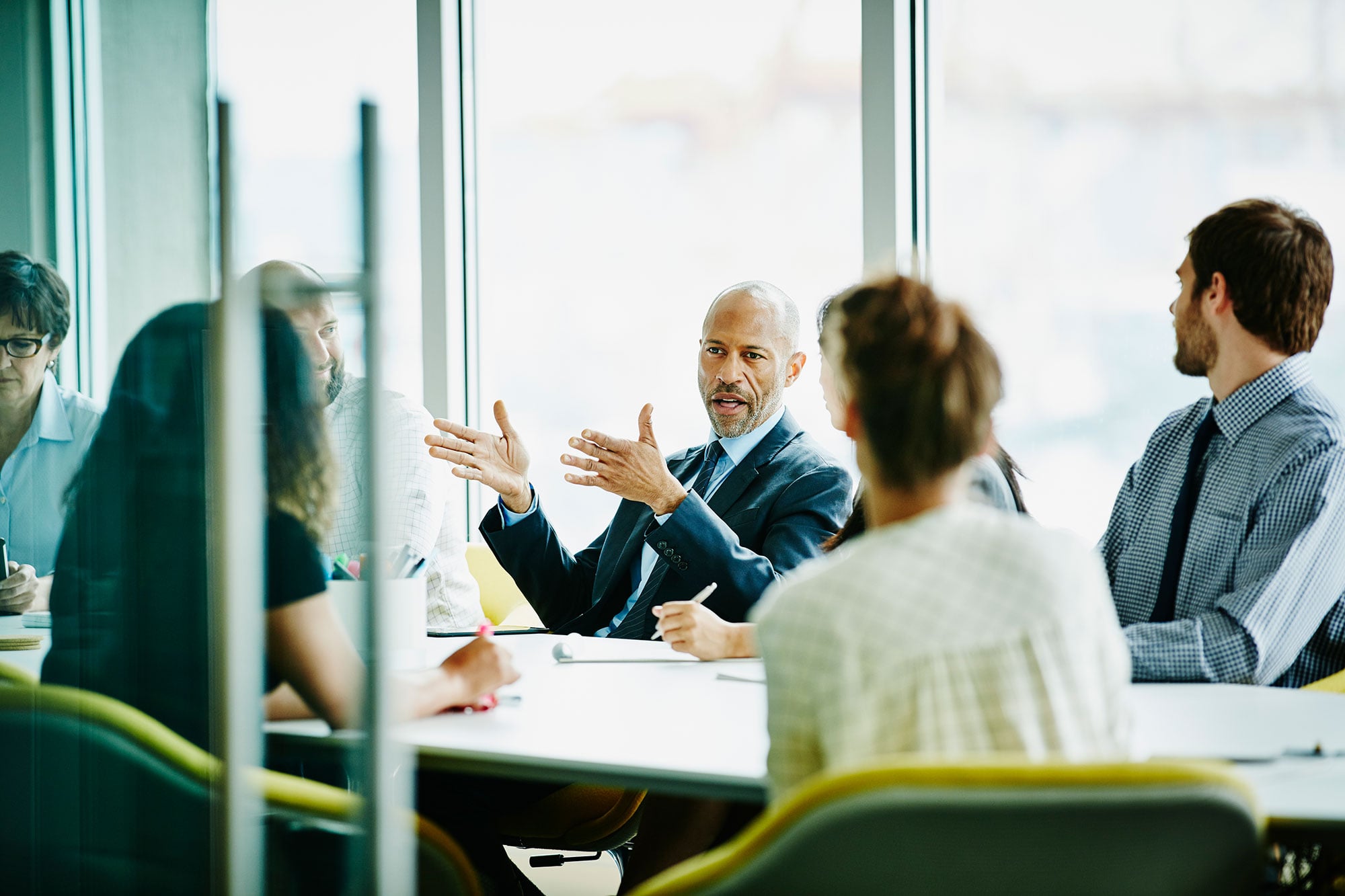 Colleagues Discussing Work Around Conference Table 