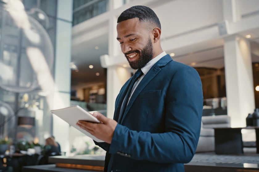 Businessperson Smiling While Looking At Tablet