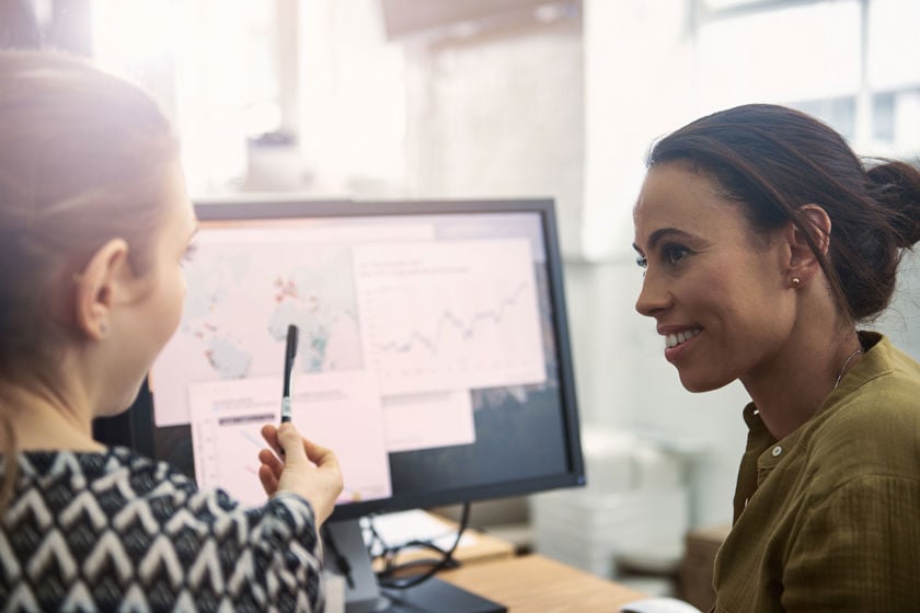Colleauges Having A Discussion About Map On Desktop Screen