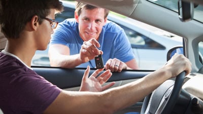 Adult Handing Car Key To Teenager 
