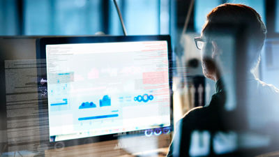 Man Reviewing Data On Computer 