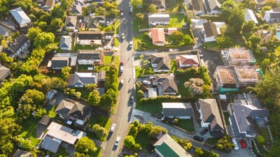 Aerial View Of Cars Driving Through Sunny Neighborhood 