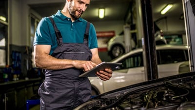 Mechanic Reviewing Data On Tablet 