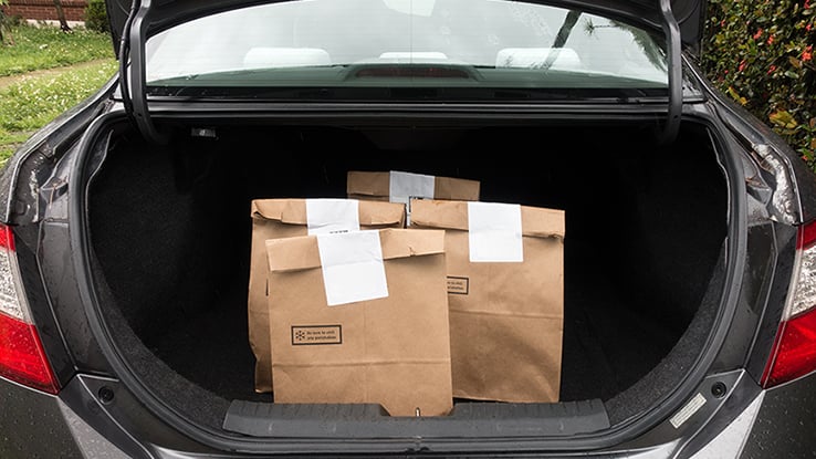 Open trunk of a personal vehicle used as part of a food delivery service.