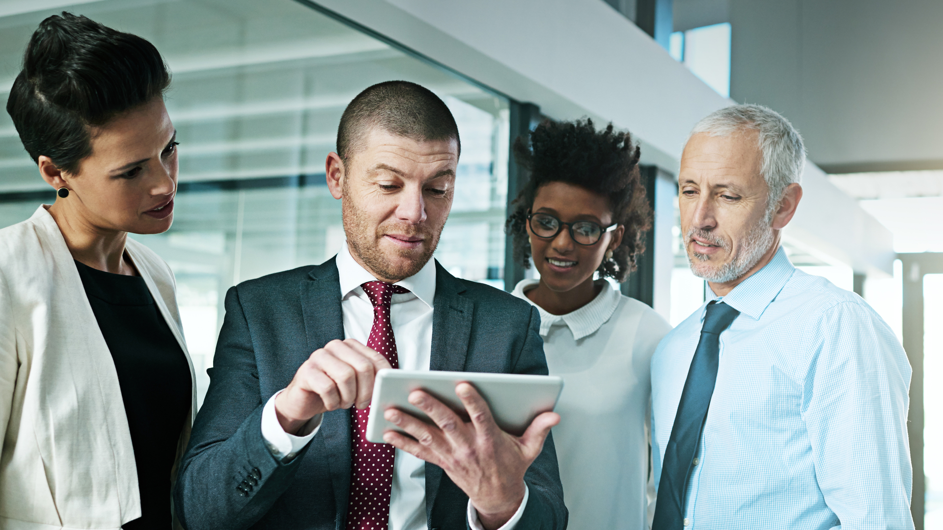 Colleagues gathered around a tablet