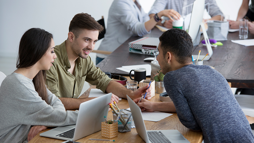 Employees meeting at desks
