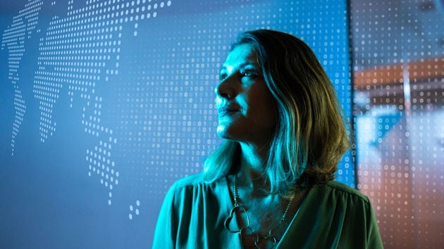 Woman Looking At World Map Made Of Data 