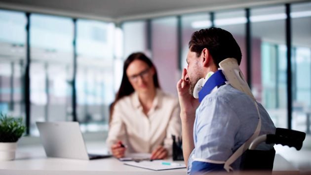 Man Stressed Wearing Neck Brace At Desk 