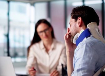 Man Stressed Wearing Neck Brace At Desk 
