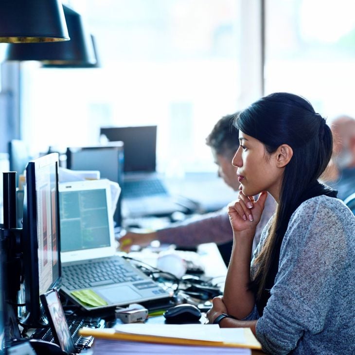 Woman Working At Desk Looking At Computer 