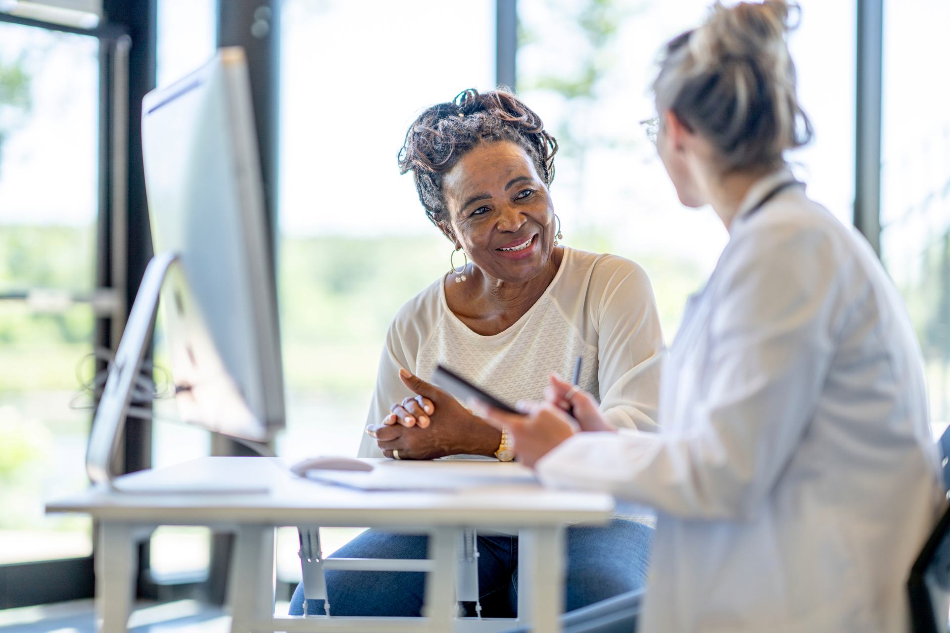 women-sitting-at-desk-talking