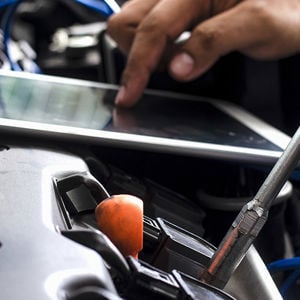 Mechanic Running Engine Diagnostics On Tablet 