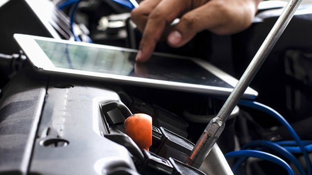 Mechanic Running Engine Diagnostics On Tablet