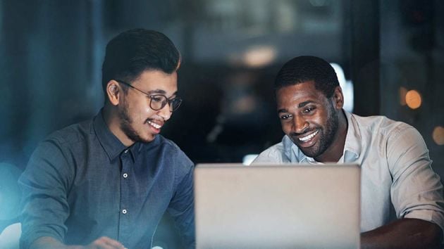 Two Male Coworkers Smiling At Laptop 