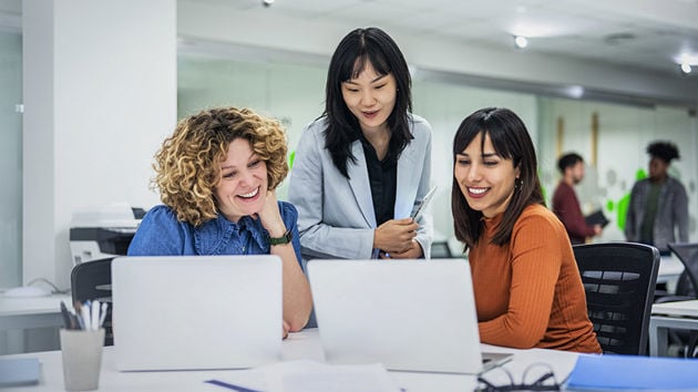 Coworkers Reviewing Data On Laptop Screens 