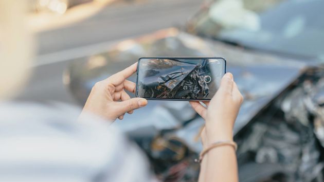 Person Taking Photo Of Car Damage 