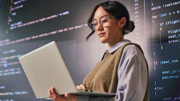 Woman Reviewing Data On Laptop Screen 