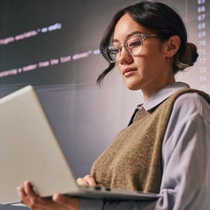 Woman Reviewing Data On Laptop Screen 