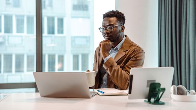Man Reading Report On Laptop 