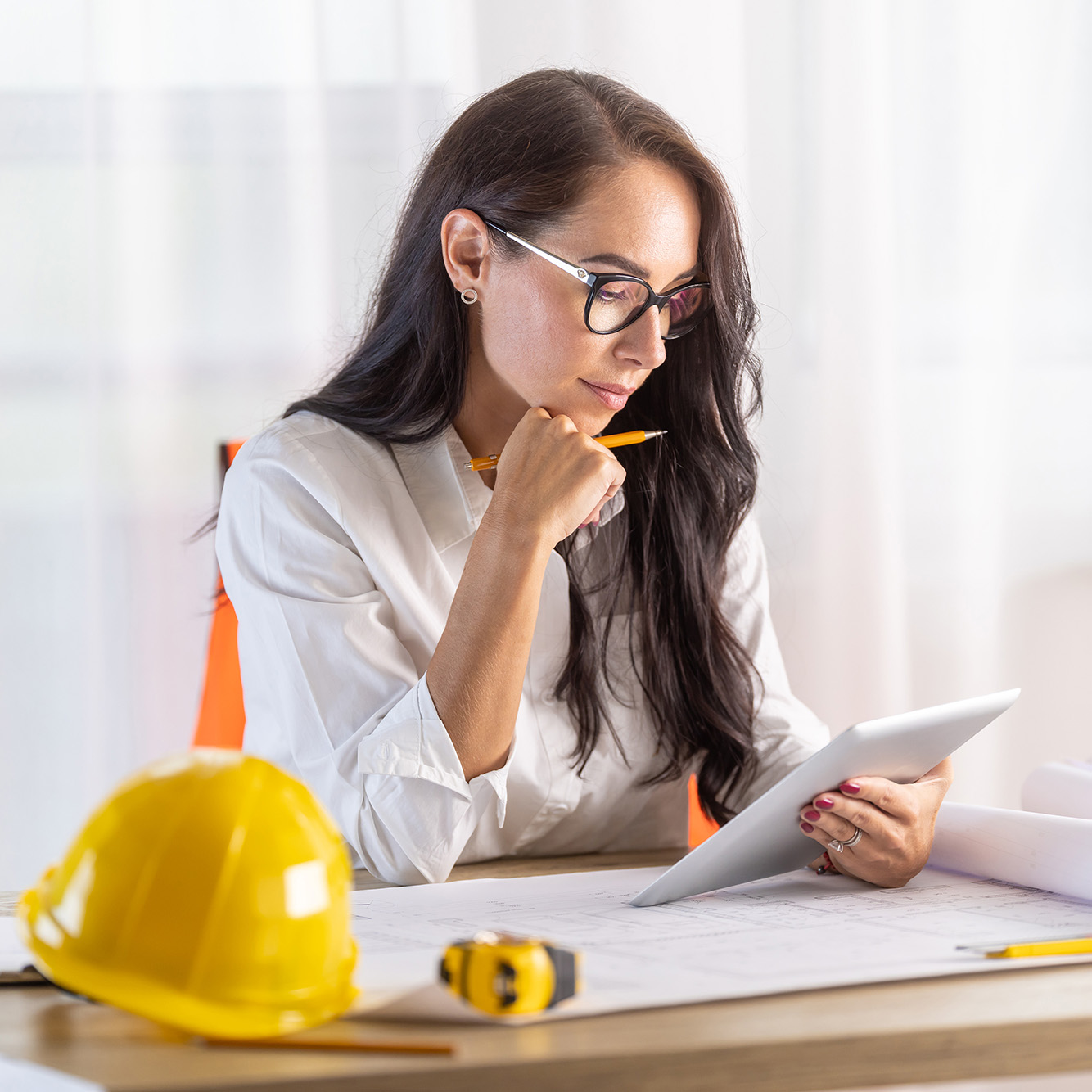 Woman With Hardhat Reviewing Tablet Computer