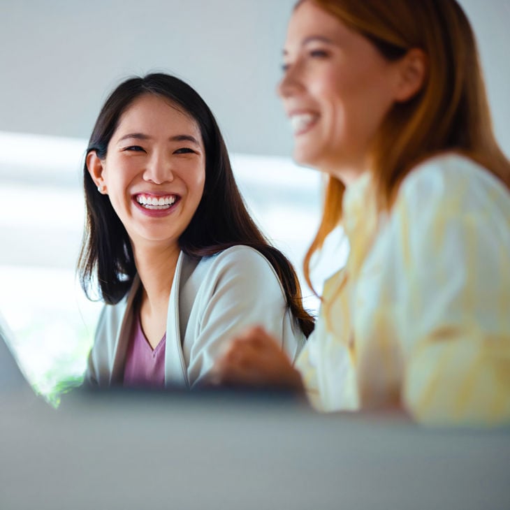 Two Women Collaborating In Office