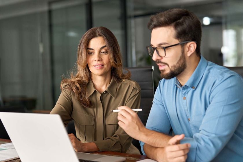 Team Reviweing Newsletter On Computer 