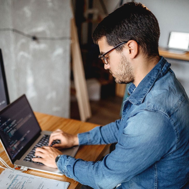Young Worker Writing Code On Laptop 