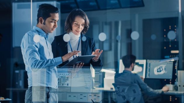 Man And Woman Reviewing Data On Tablet 