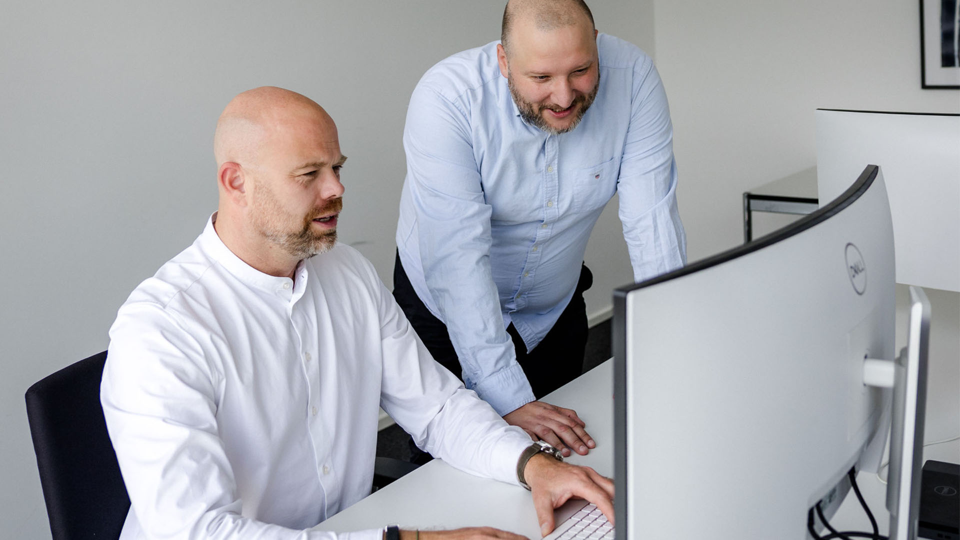 colleagues reviewing data on computer monitor