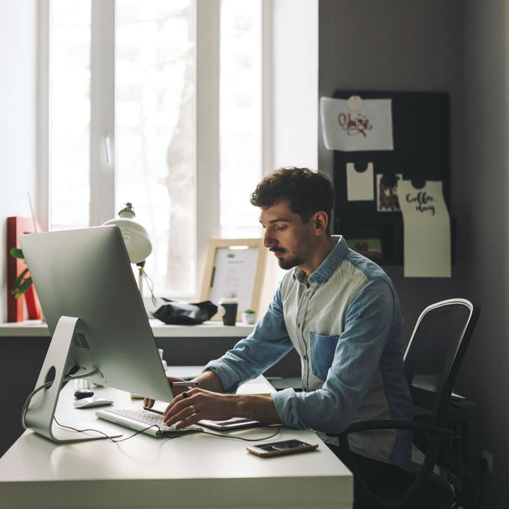 Person Typing On Desktop Computer In Home Office 