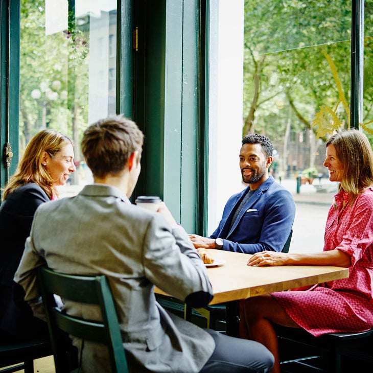 Colleagues Chatting In Coffee Shop