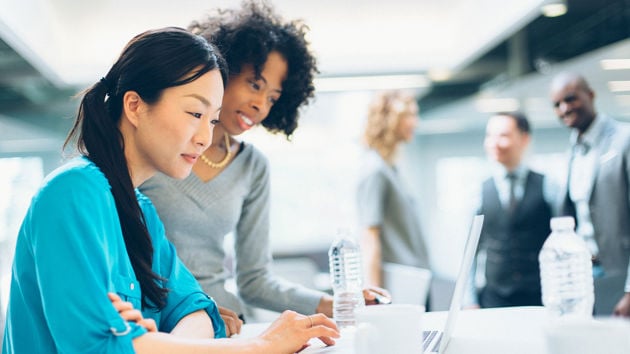 Colleagues Collaborating Over Laptop 