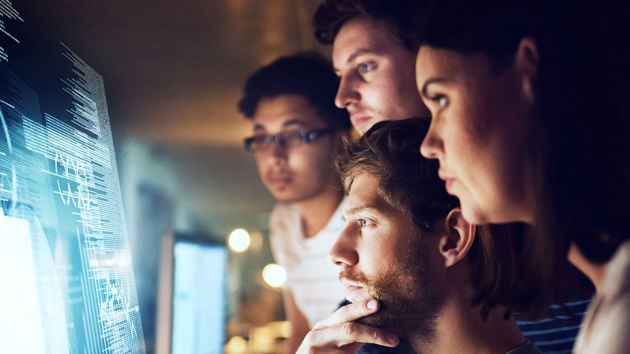 Individuals Reviewing Data On Screen 