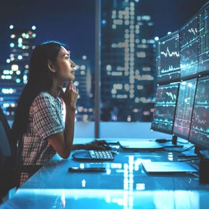 Woman Reviewing 6 Monitors Of Data 