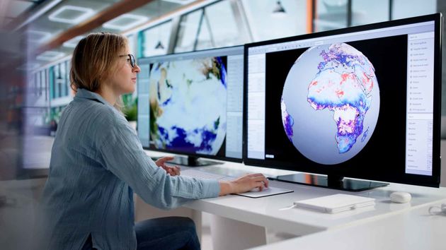 Woman Looking At Screen With Globe 