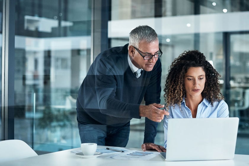 Two Colleagues Reviewing Laptop In Office 