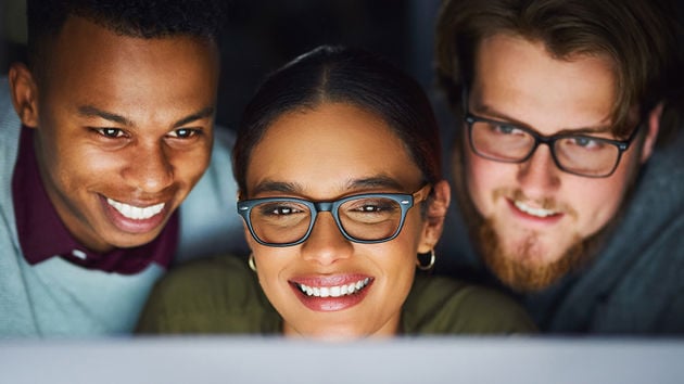 Coworkers Reviewing Data On Computer Monitor 