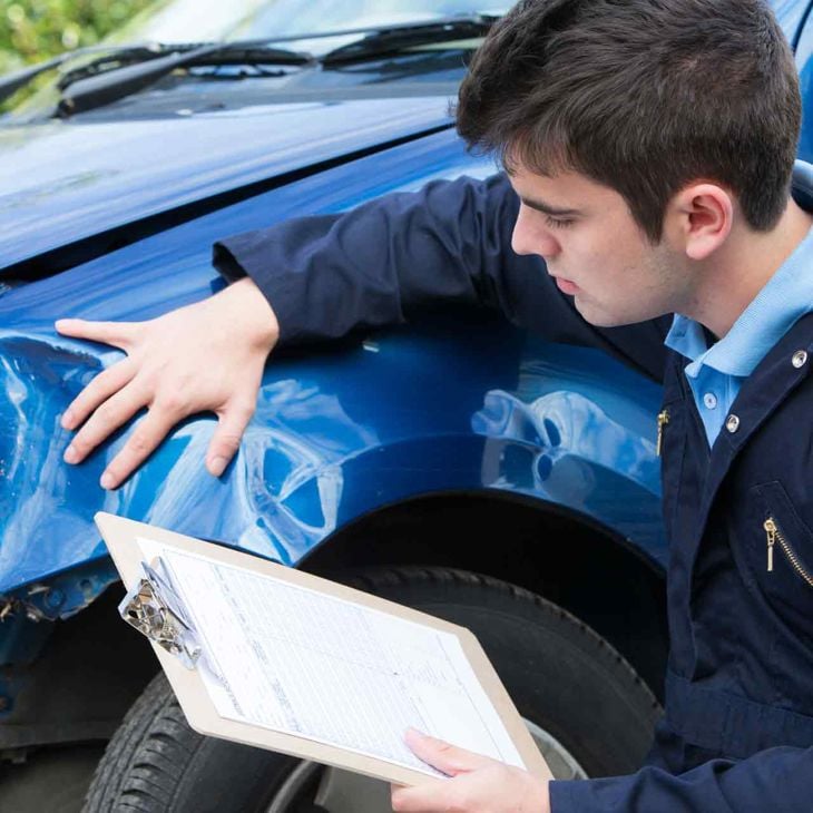 Man With Clipboard Inspecting Broken Fender 