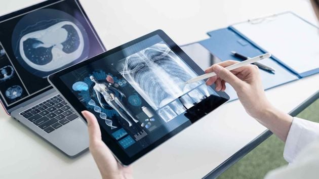 Hands Holding A Tablet With Body Scans 