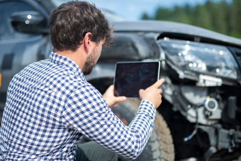 Man Taking Photo Of Car Damage With Tablet 