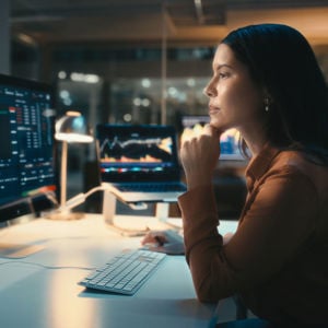 Woman Reviewing Data On Screens 